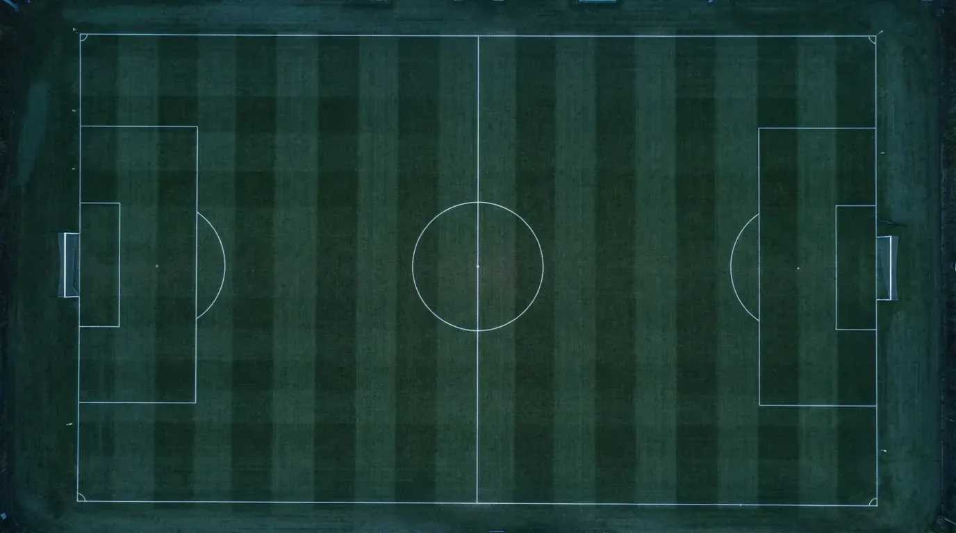 Ein Fussballplatz von oben gesehen, die Linien bilden ein helles Muster auf dem Rasen, Drohnenperspektive in der Morgendämmerung.