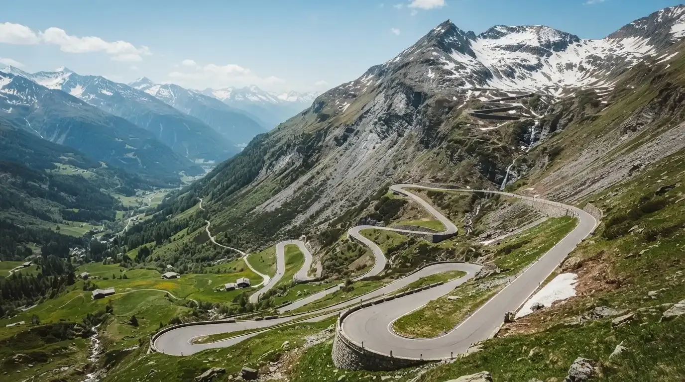 Eine Passstrasse zieht sich in Kehren einen Alpenhang hinauf, kein Fahrzeug ist zu sehen.